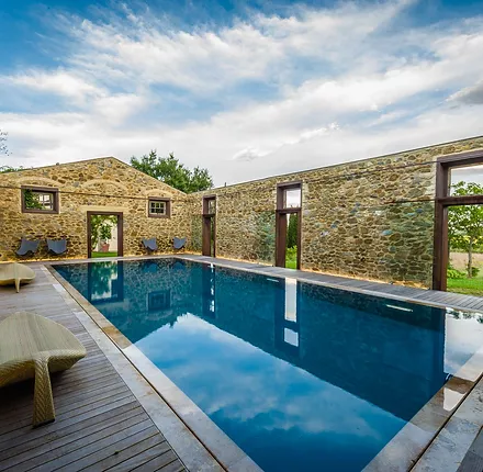 Piscina ricavata in una stalla ormai in disuso e priva del tetto - realizzata con tecnologia Myrtha e bordo a sfioro Trilogy.